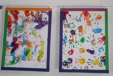 Bilder mit bunten Handabdrücken der Kinder sind in der Kita ausgestellt